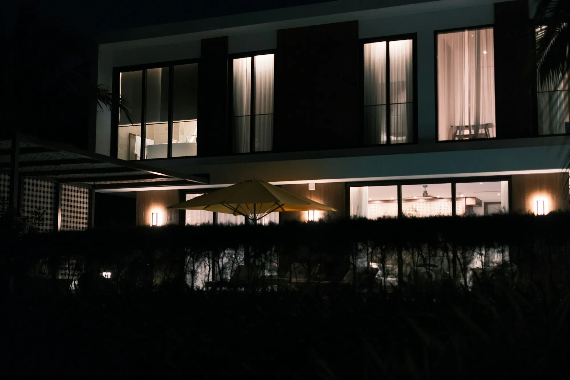 A finished modern home with its windows lit at night