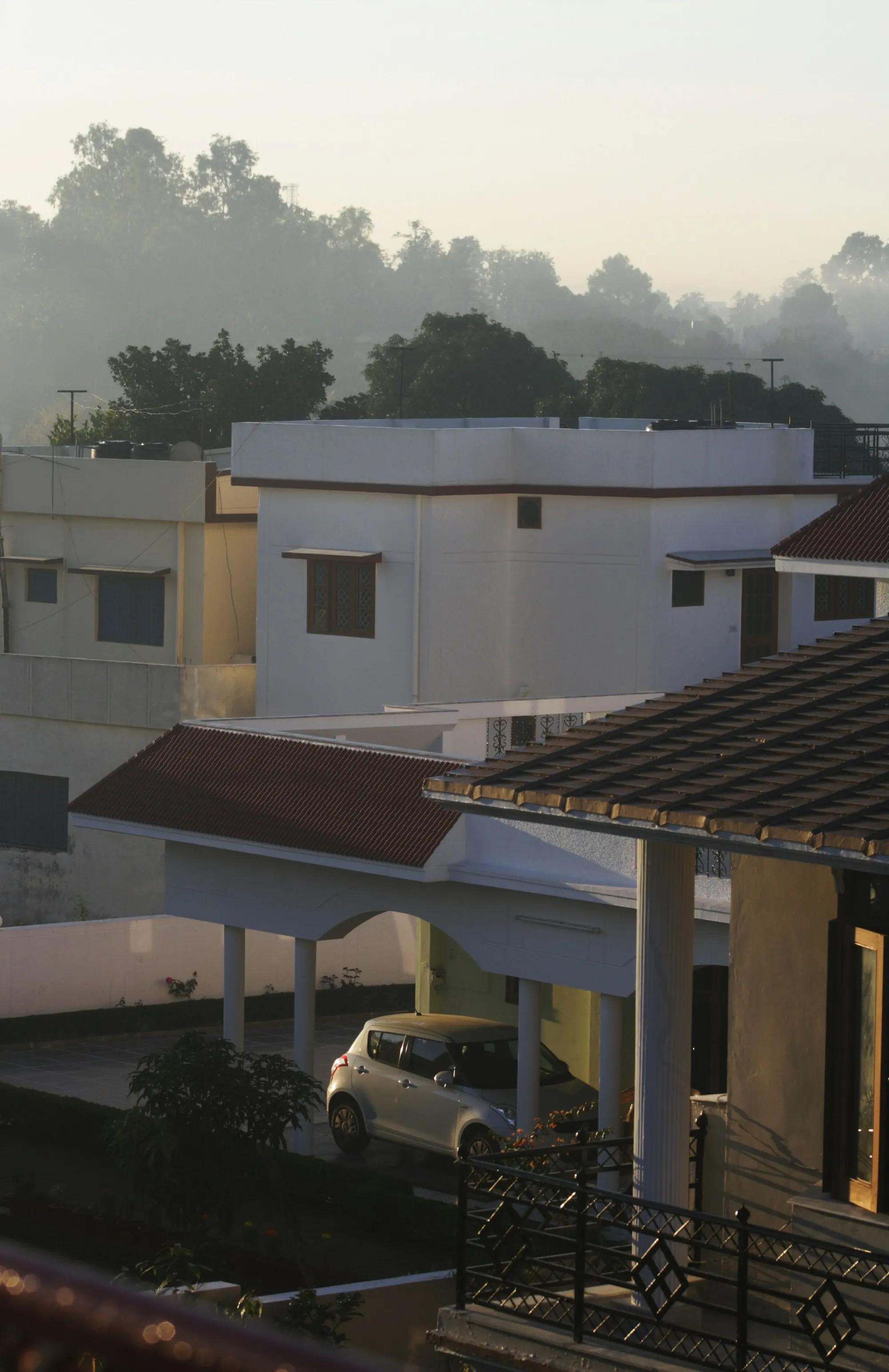 Homes on a hillside street in India in the morning mist