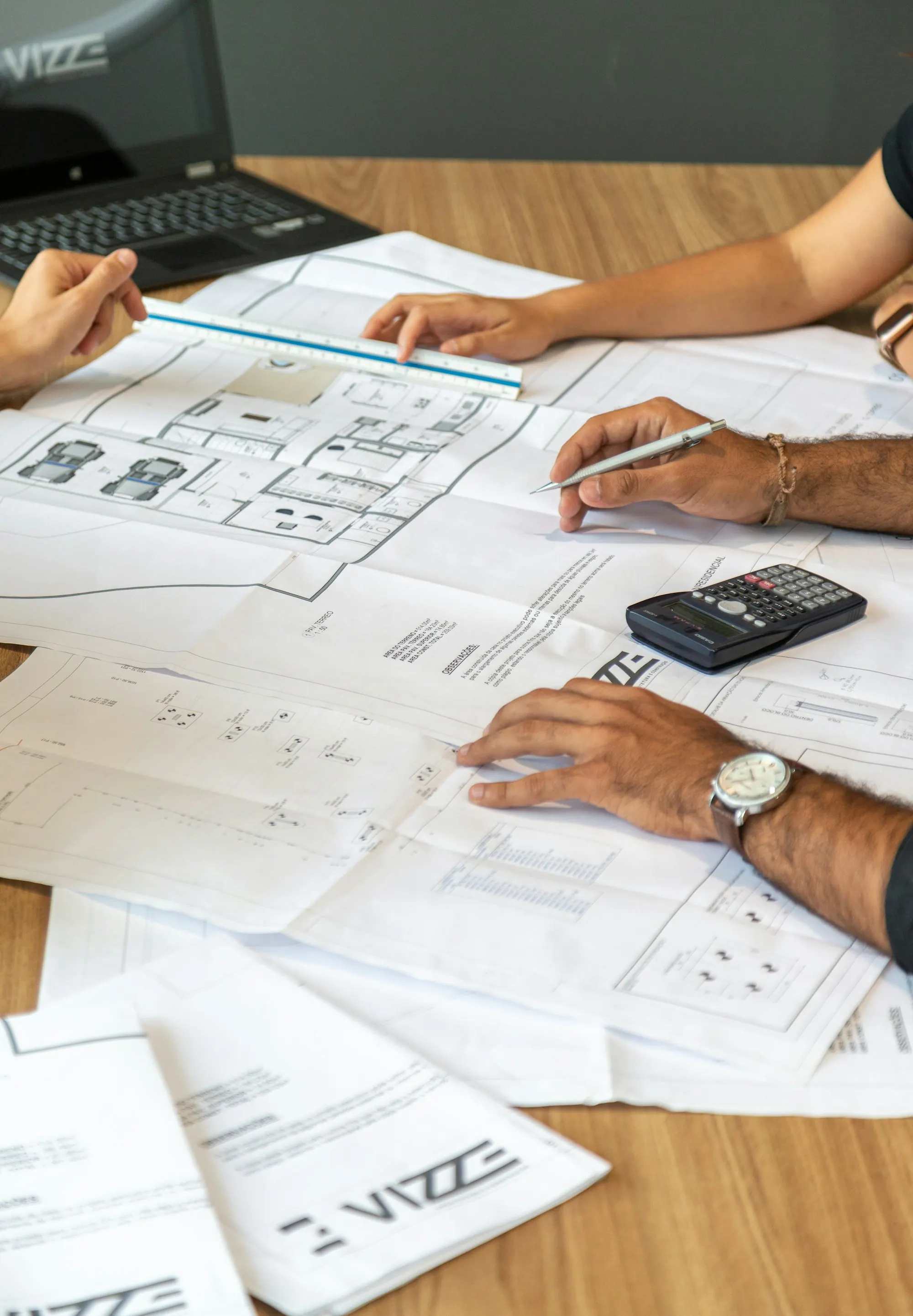 Two people reviewing architectural plans on a desk