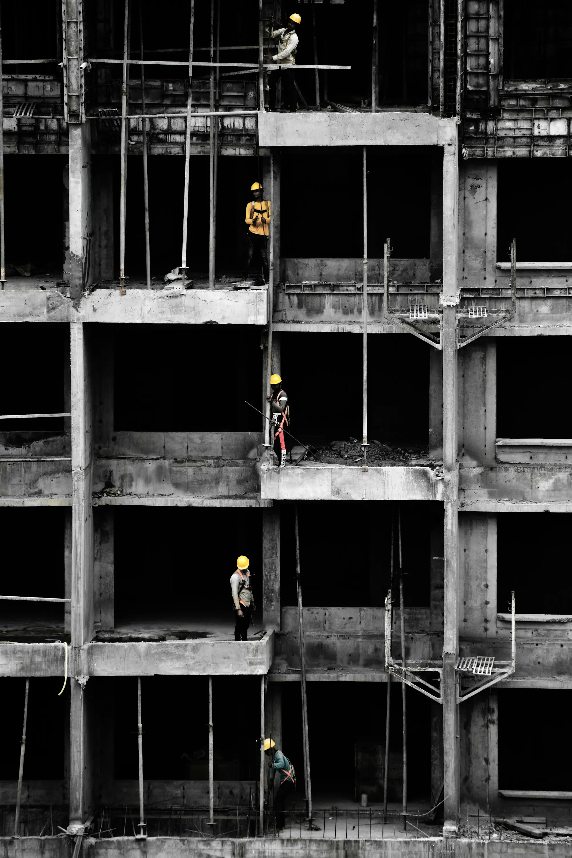 A concrete frame of a building under construction, in black and white