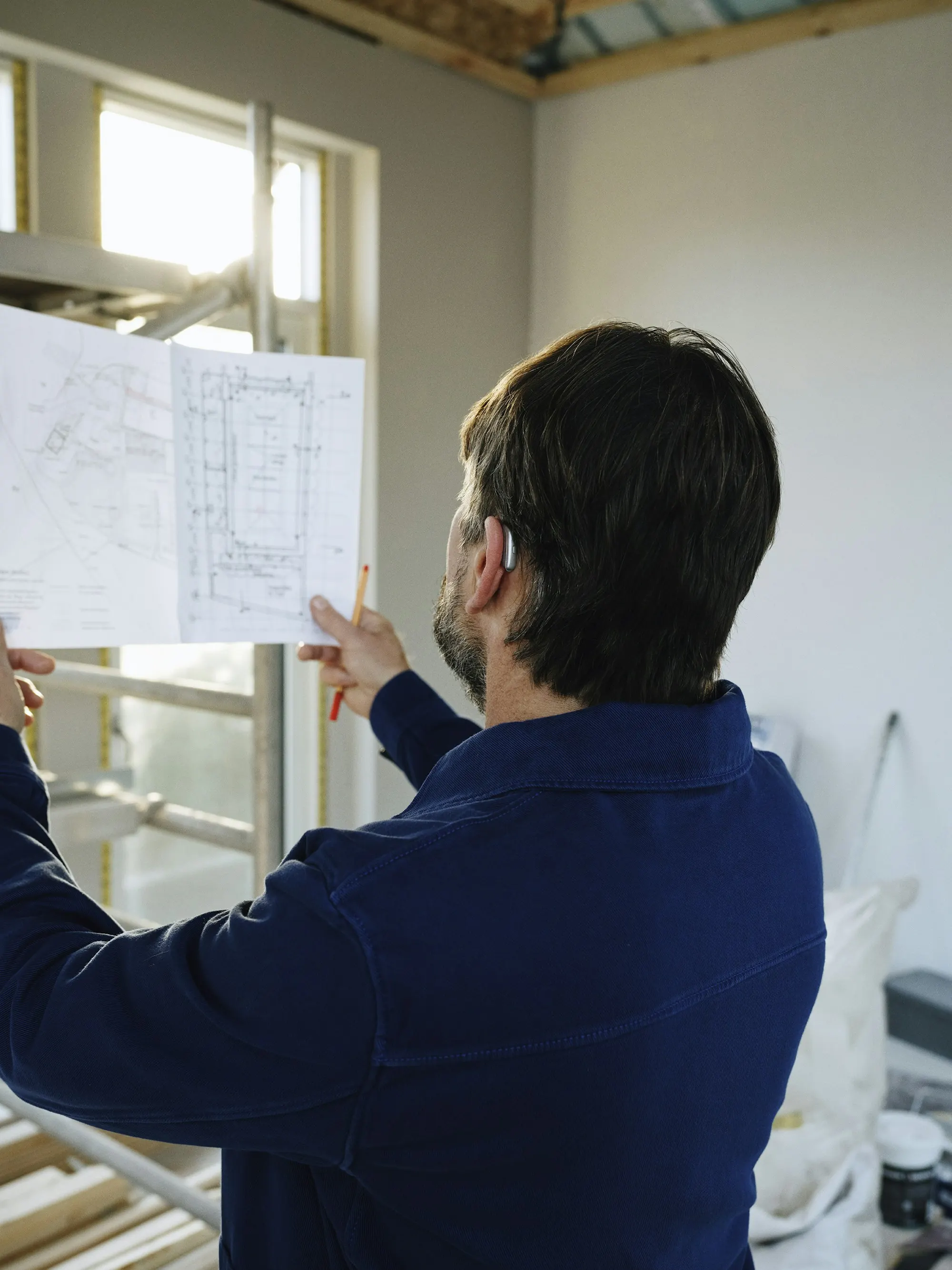 A man studying a set of drawings on a building site